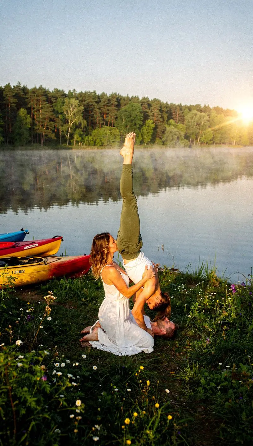 Dwoje ludzi wykonujących wspólną pozycję jogi na plaży.